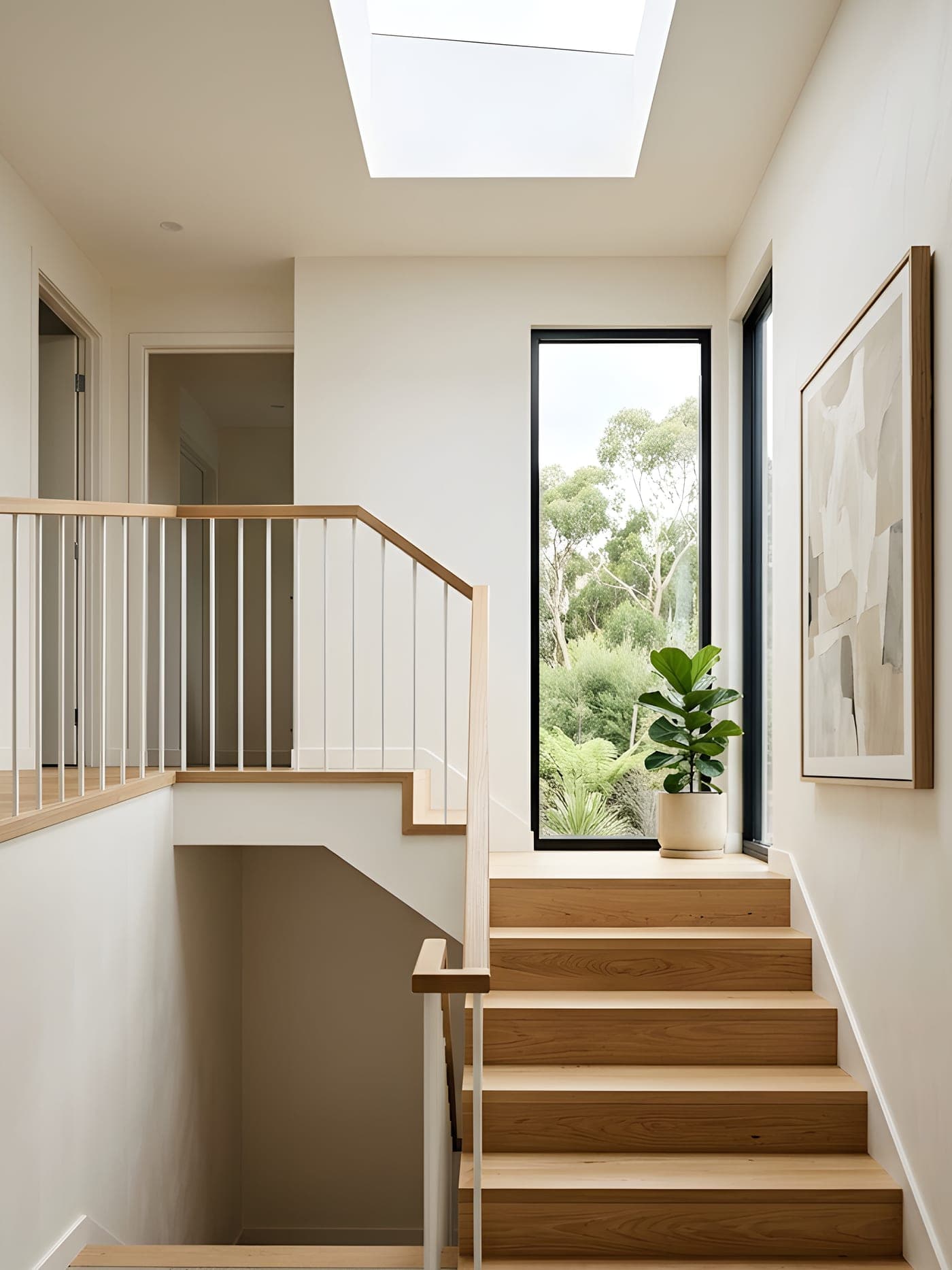 A modern white staircase with timber handrail detail
