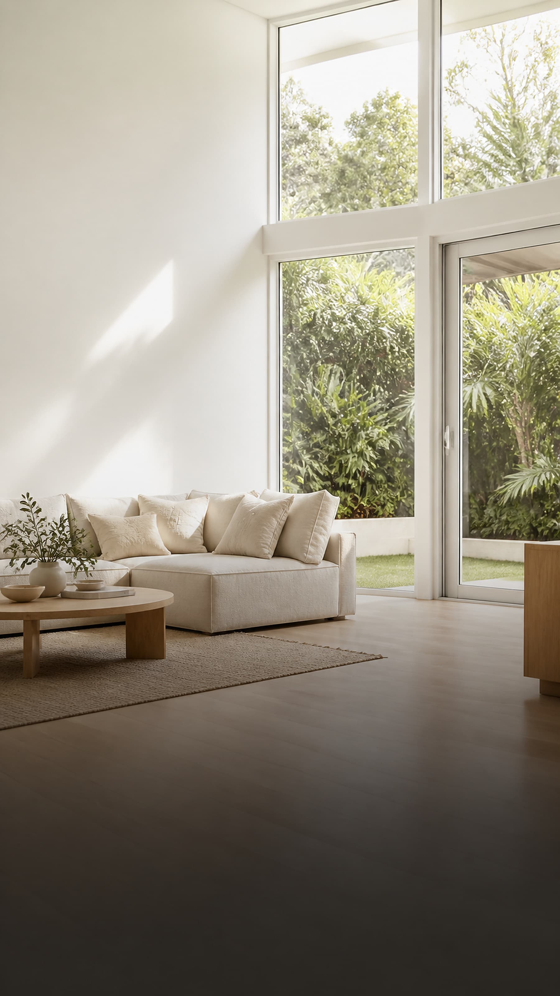 A calm, light-filled living room in warm whites with natural-fibre styling